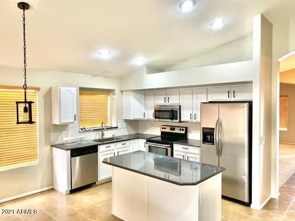 a kitchen with stainless steel appliances granite countertop a sink a stove and a refrigerator