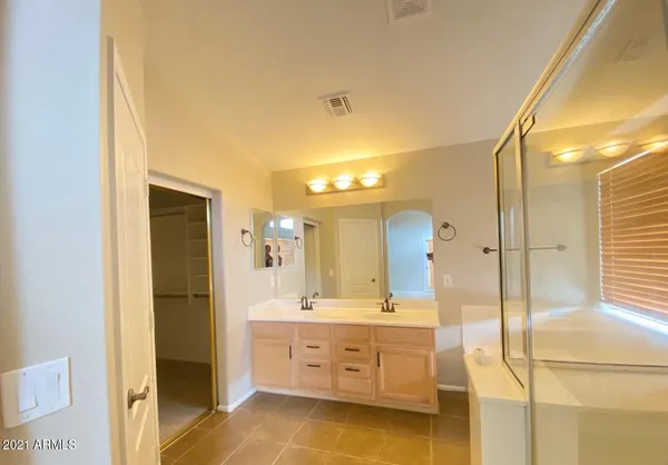 a spacious bathroom with a double vanity sink and a mirror