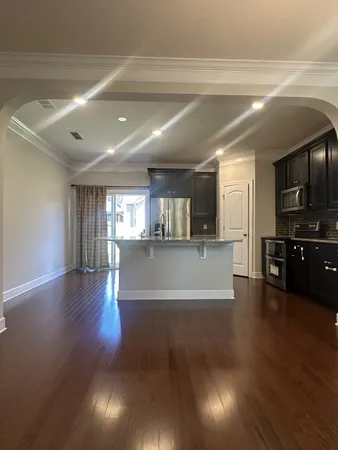 a view of a kitchen with furniture and wooden floor