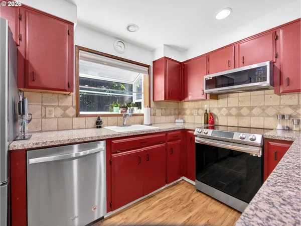 a kitchen with stainless steel appliances granite countertop a sink stove and cabinets