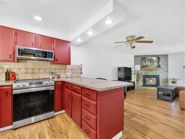 a kitchen with granite countertop a stove top oven and cabinets