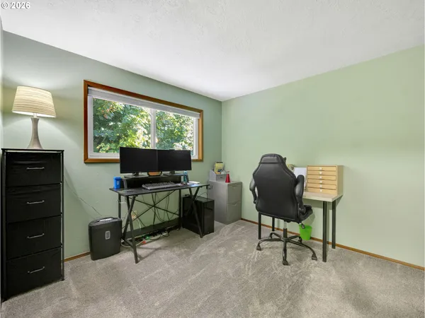 a view of a workspace with furniture and a window