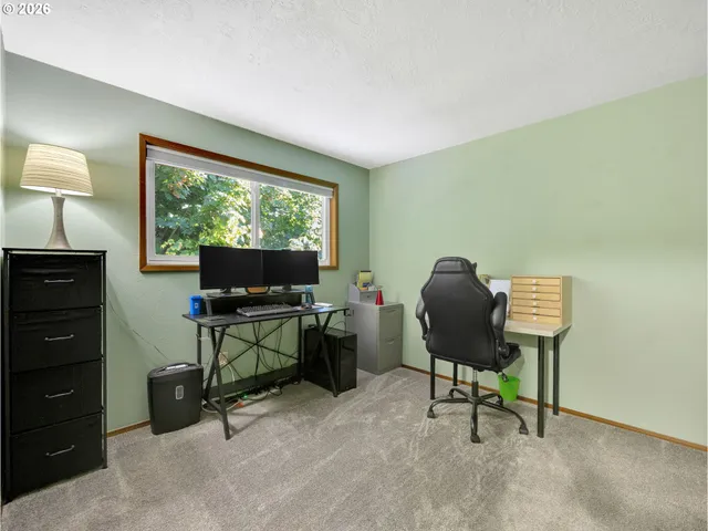 a view of a workspace with furniture and a window