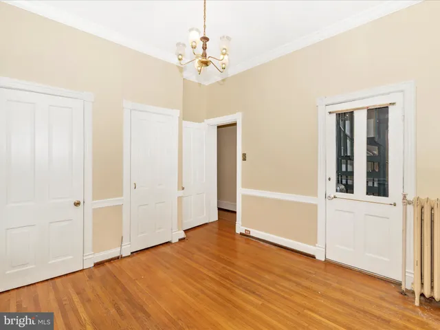 a view of empty room with wooden floor