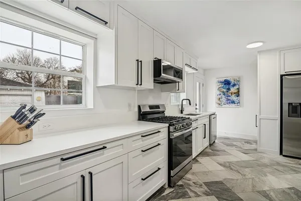 a kitchen with stainless steel appliances a stove sink and refrigerator
