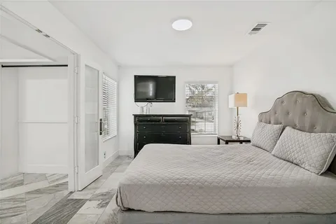 a bedroom with a bed and a flat screen tv