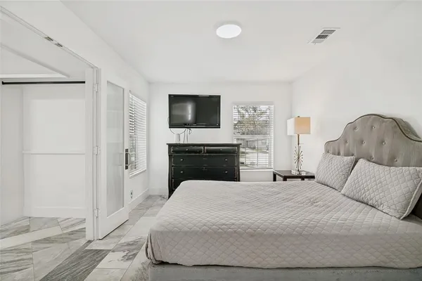 a bedroom with a bed and a flat screen tv