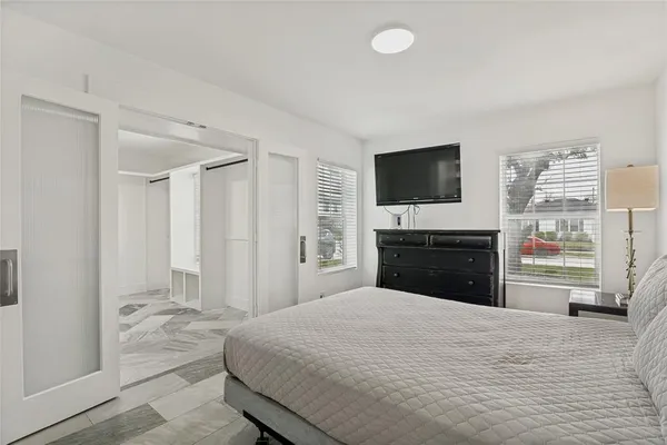 a bedroom with a bed and a flat screen tv