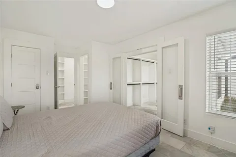 a bedroom with a bed closet and a window