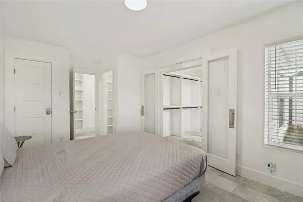 a bedroom with a bed closet and a window
