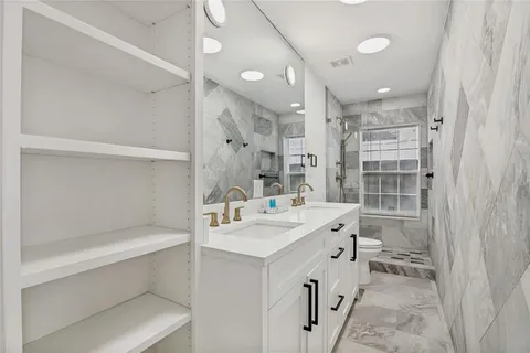 a bathroom with a sink a toilet and shower