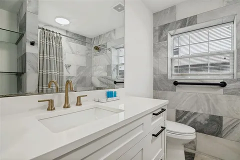a bathroom with a sink toilet and shower