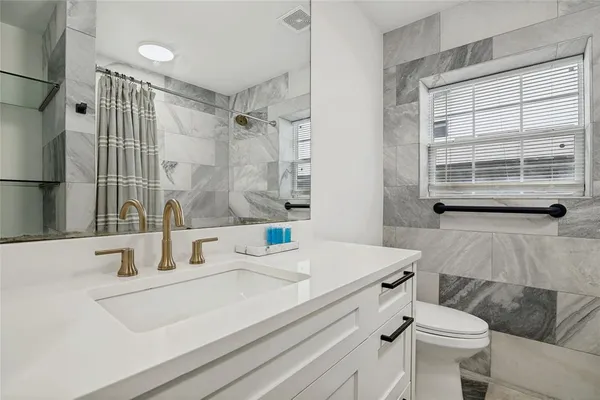 a bathroom with a sink toilet and shower