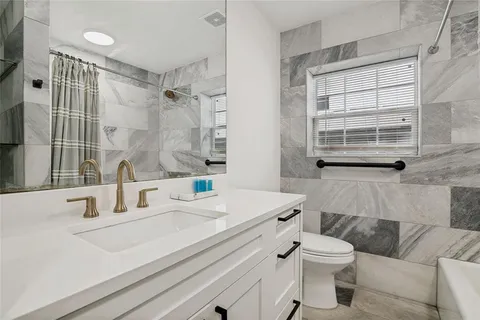 a bathroom with a sink toilet vanity and tub