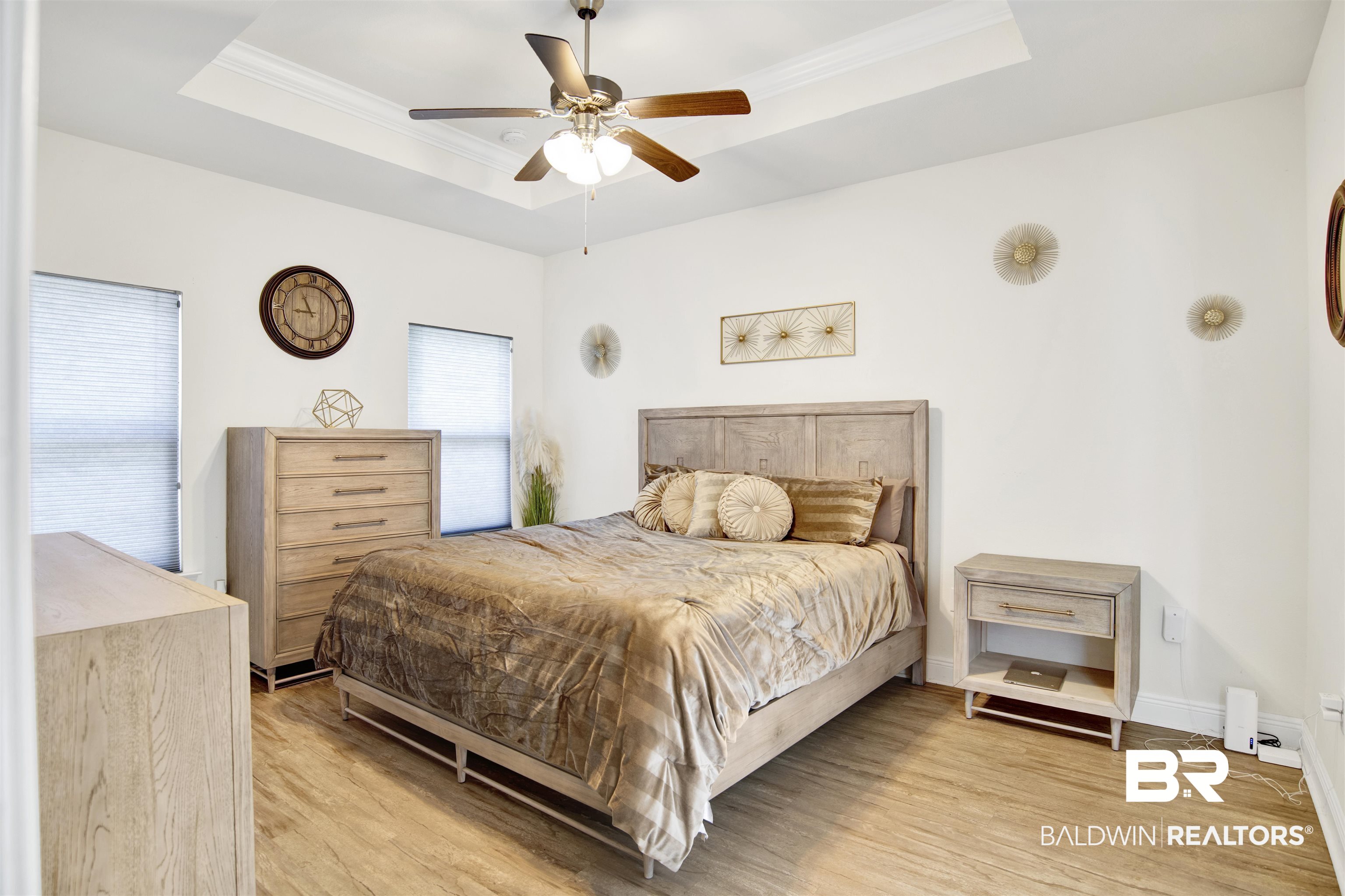 1468 Surrey Loop Foley, AL 36535 - Photo 20 of 28 Bedroom featuring a tray ceiling, light wood-type flooring, crown molding, ceiling fan, and baseboards