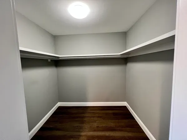 a view of a room with wooden floor and white walls