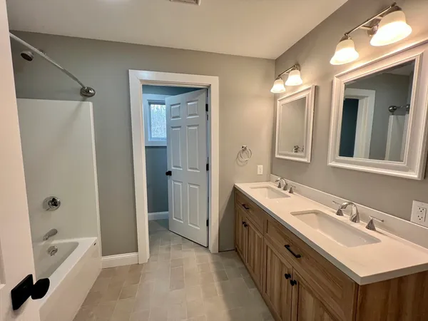 a spacious bathroom with a double vanity sink mirror double and bathtub