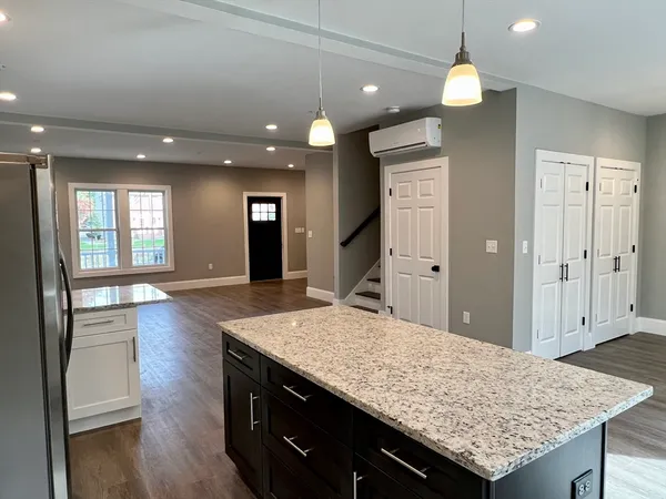 a view of kitchen island a sink wooden floor and a living room