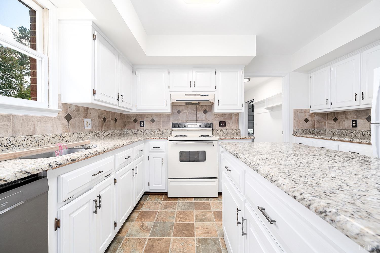 1309 White Fall Road Gretna, VA 24557 - Photo 15 of 64 a kitchen with granite countertop white cabinets and white appliances