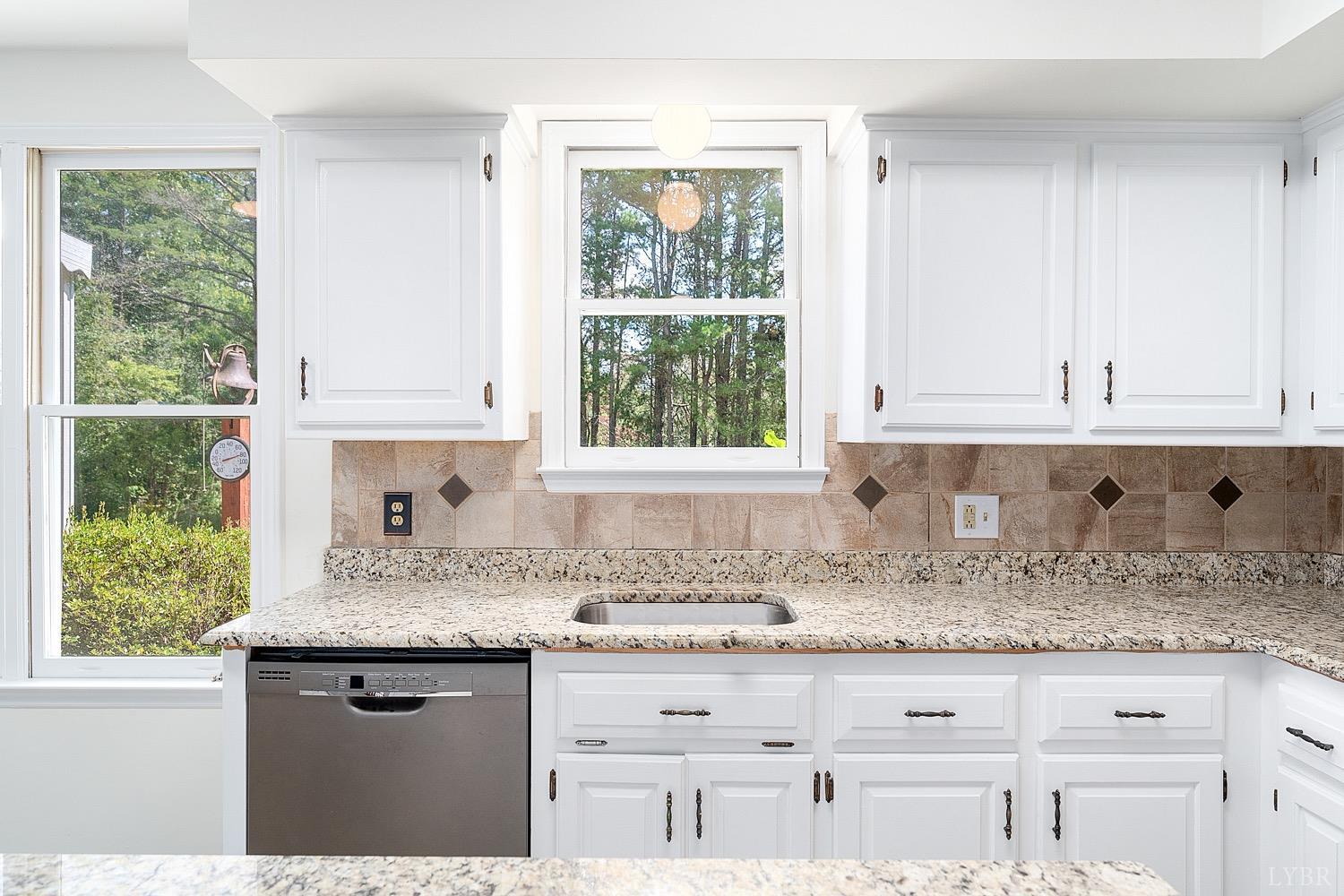 1309 White Fall Road Gretna, VA 24557 - Photo 17 of 64 a kitchen with granite countertop white cabinets and a window