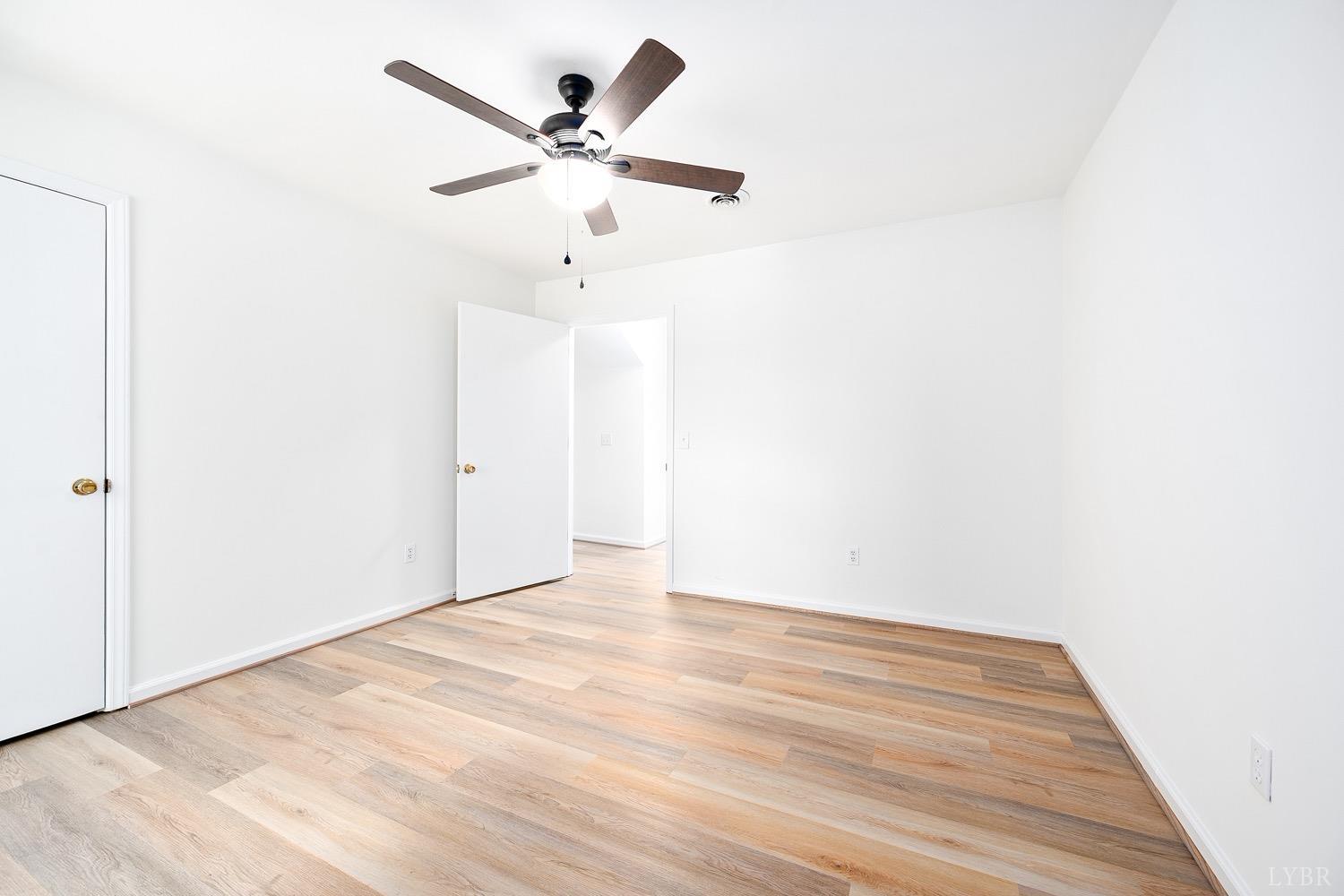 1309 White Fall Road Gretna, VA 24557 - Photo 43 of 64 an empty room with wooden floor and a ceiling fan