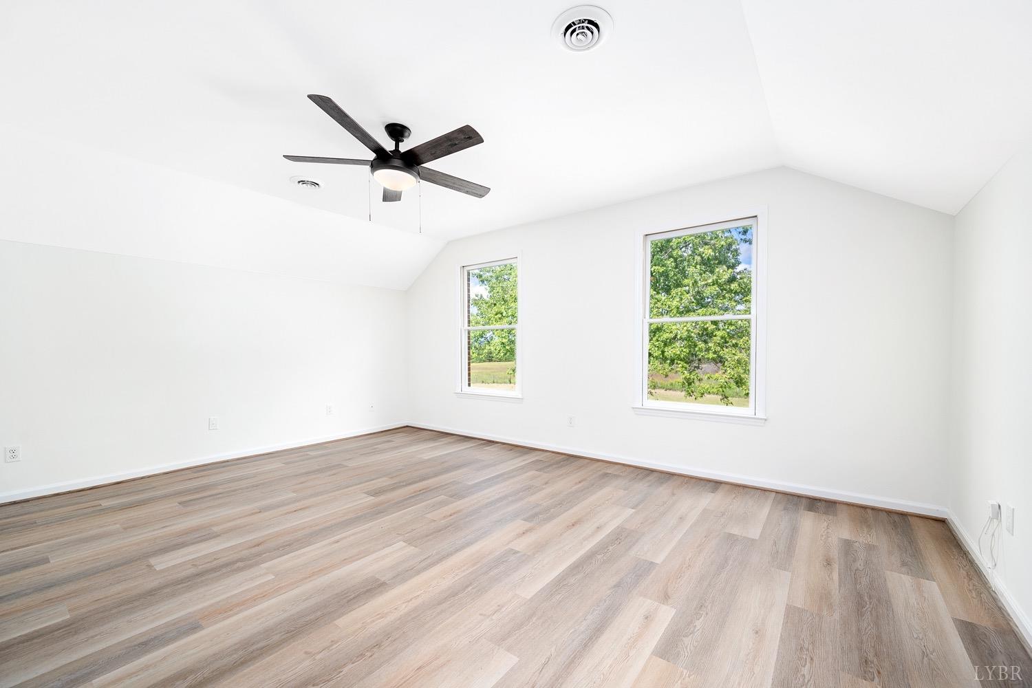 1309 White Fall Road Gretna, VA 24557 - Photo 44 of 64 an empty room with wooden floor a ceiling fan and windows