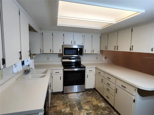 a kitchen with cabinets appliances and a window