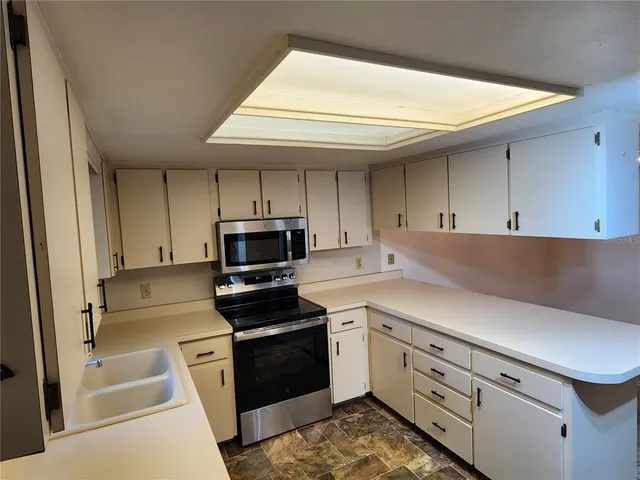 a kitchen with white cabinets and stainless steel appliances