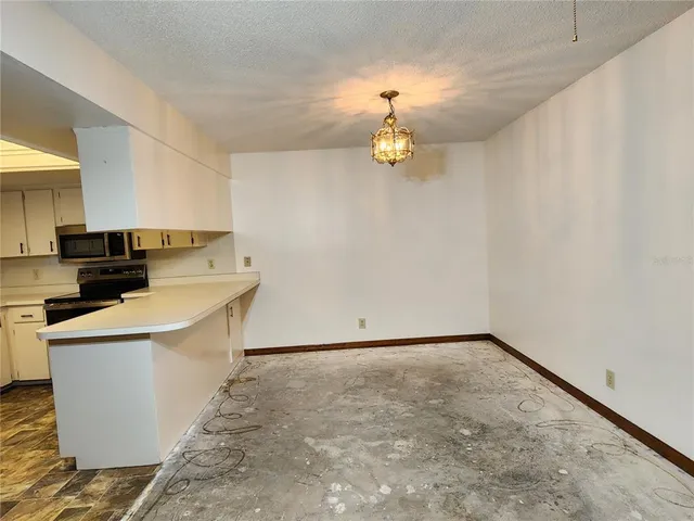 a view of a kitchen with a sink and dishwasher a stove top oven with wooden floor