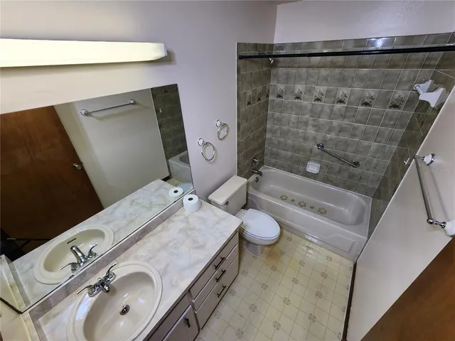 a bathroom with a granite countertop sink a toilet and shower