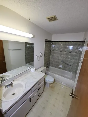 a bathroom with a granite countertop sink a toilet and shower