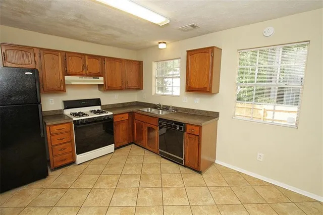a kitchen with stainless steel appliances granite countertop a refrigerator stove and cabinets