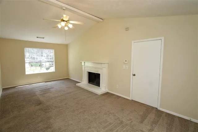 an empty room with windows and chandelier fan