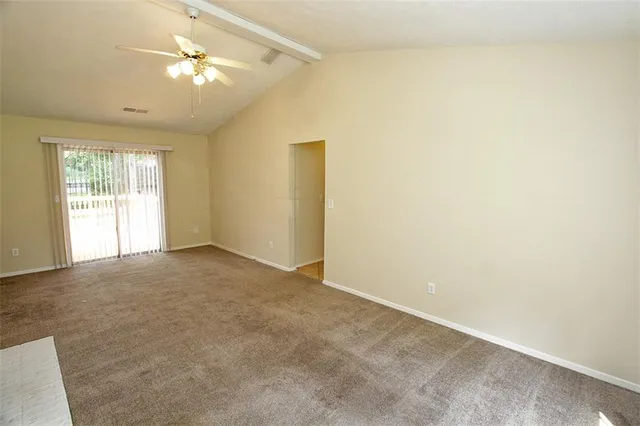 an empty room with a fireplace and fan
