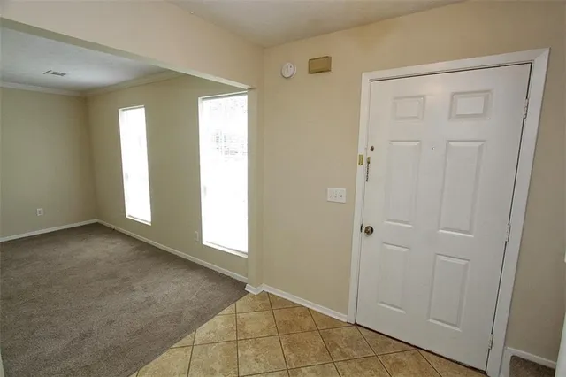 a view of an empty room with window and closet area