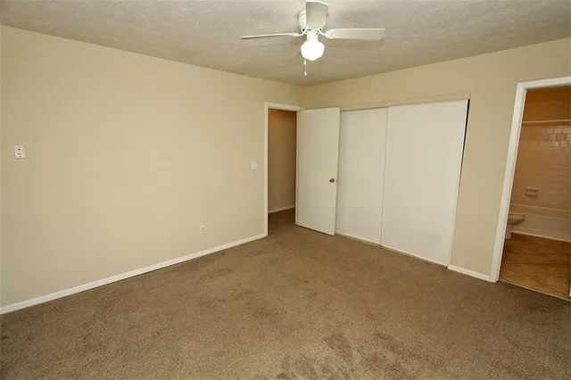 a bathroom with a granite countertop bathtub shower sink vanity and toilet