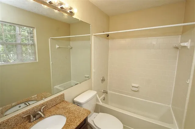 an empty room with a window and ceiling fan