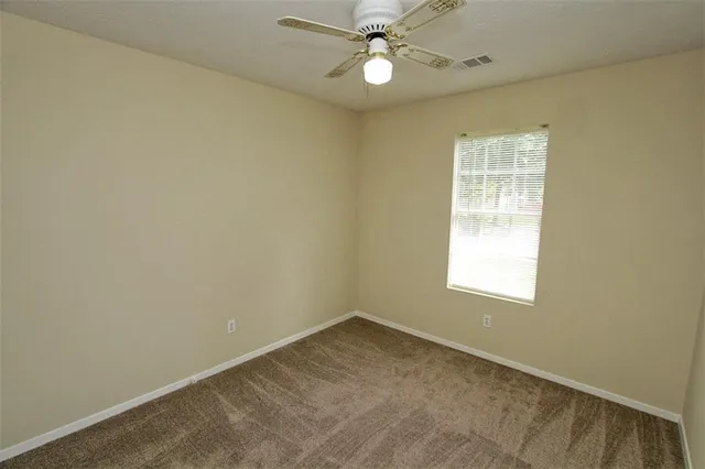an empty room with a chandelier fan and a closet
