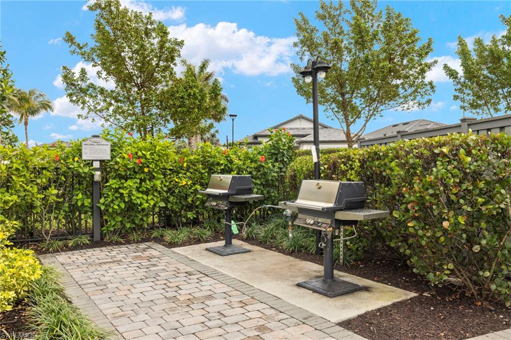 2170 Yellowfin Circle Naples, FL 34114 - Photo 24 of 26 a backyard view of a house with fountain table and chairs