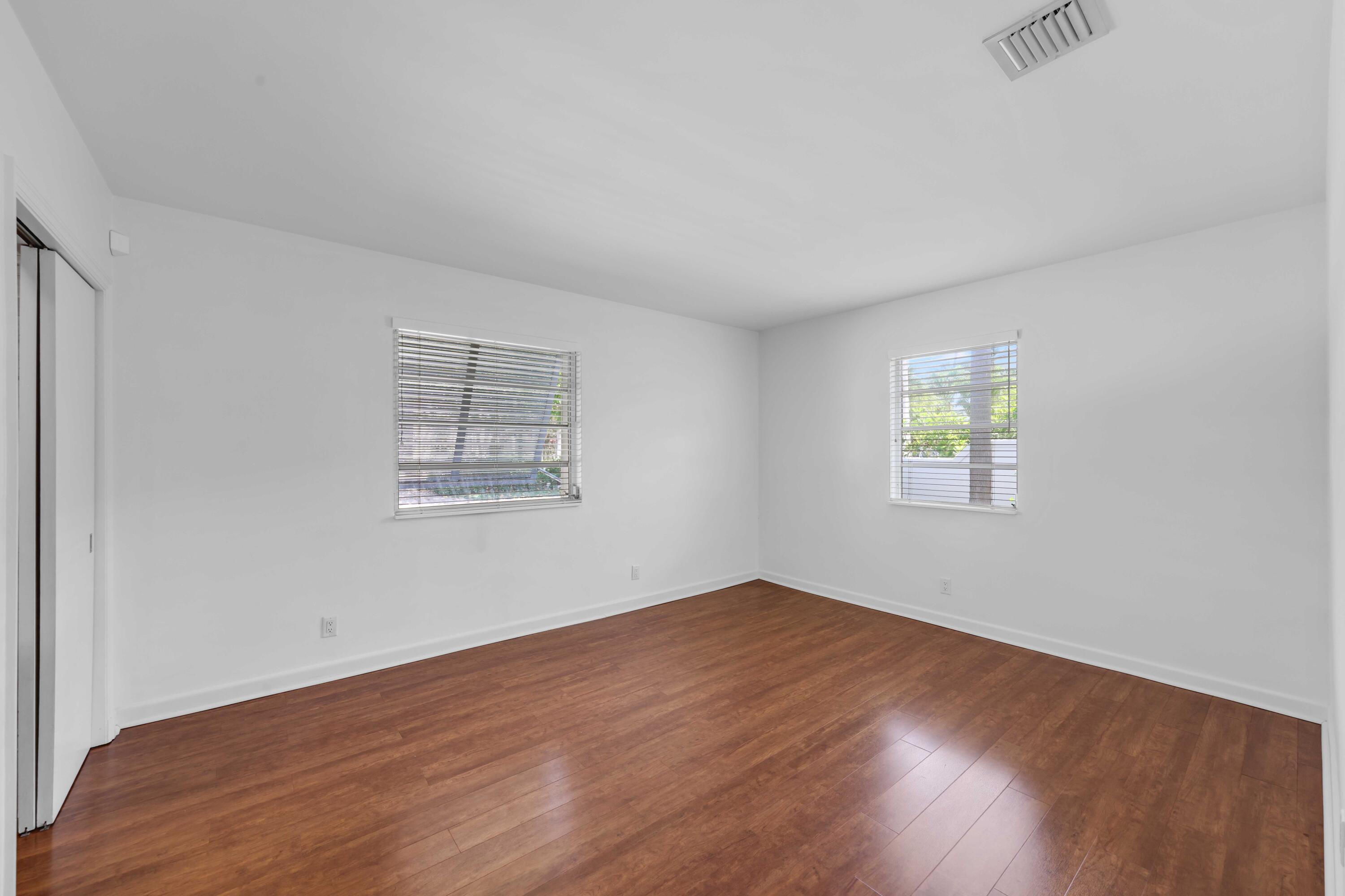 246 Merrain Road Palm Beach, FL 33480 - Photo 11 of 31 an empty room with wooden floor and windows