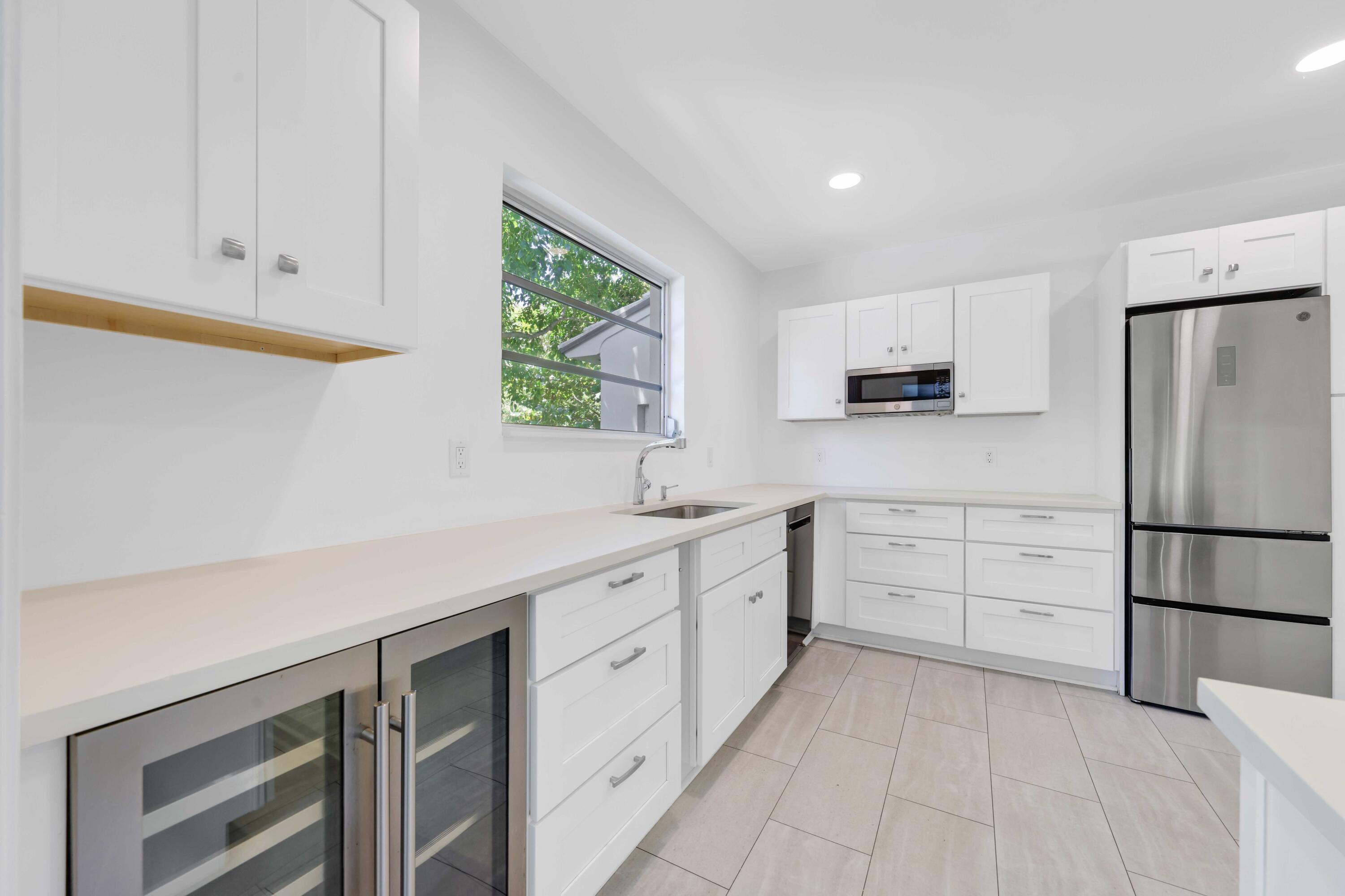 246 Merrain Road Palm Beach, FL 33480 - Photo 13 of 31 a kitchen with white cabinets and stainless steel appliances