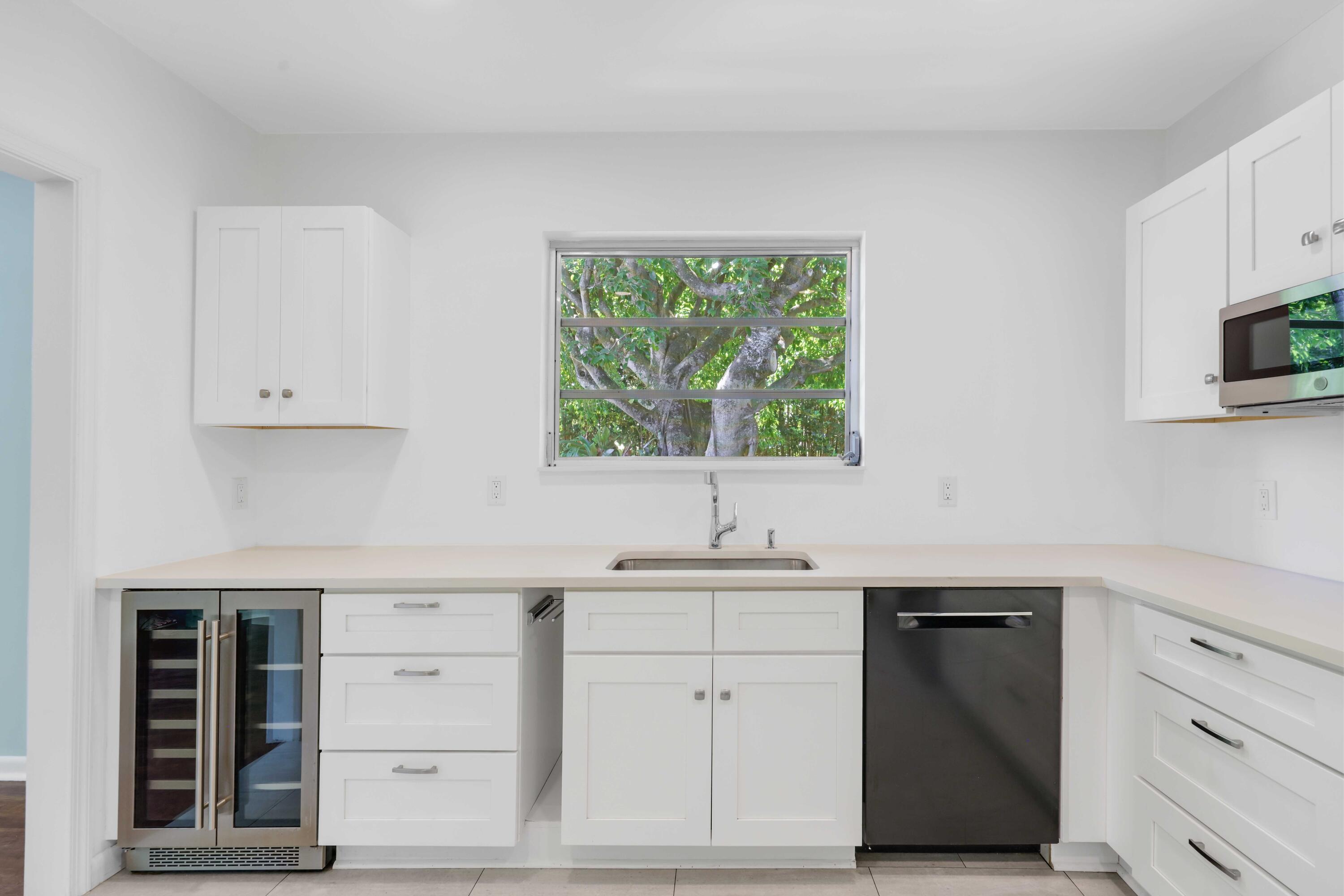 246 Merrain Road Palm Beach, FL 33480 - Photo 14 of 31 a kitchen with white cabinets and sink