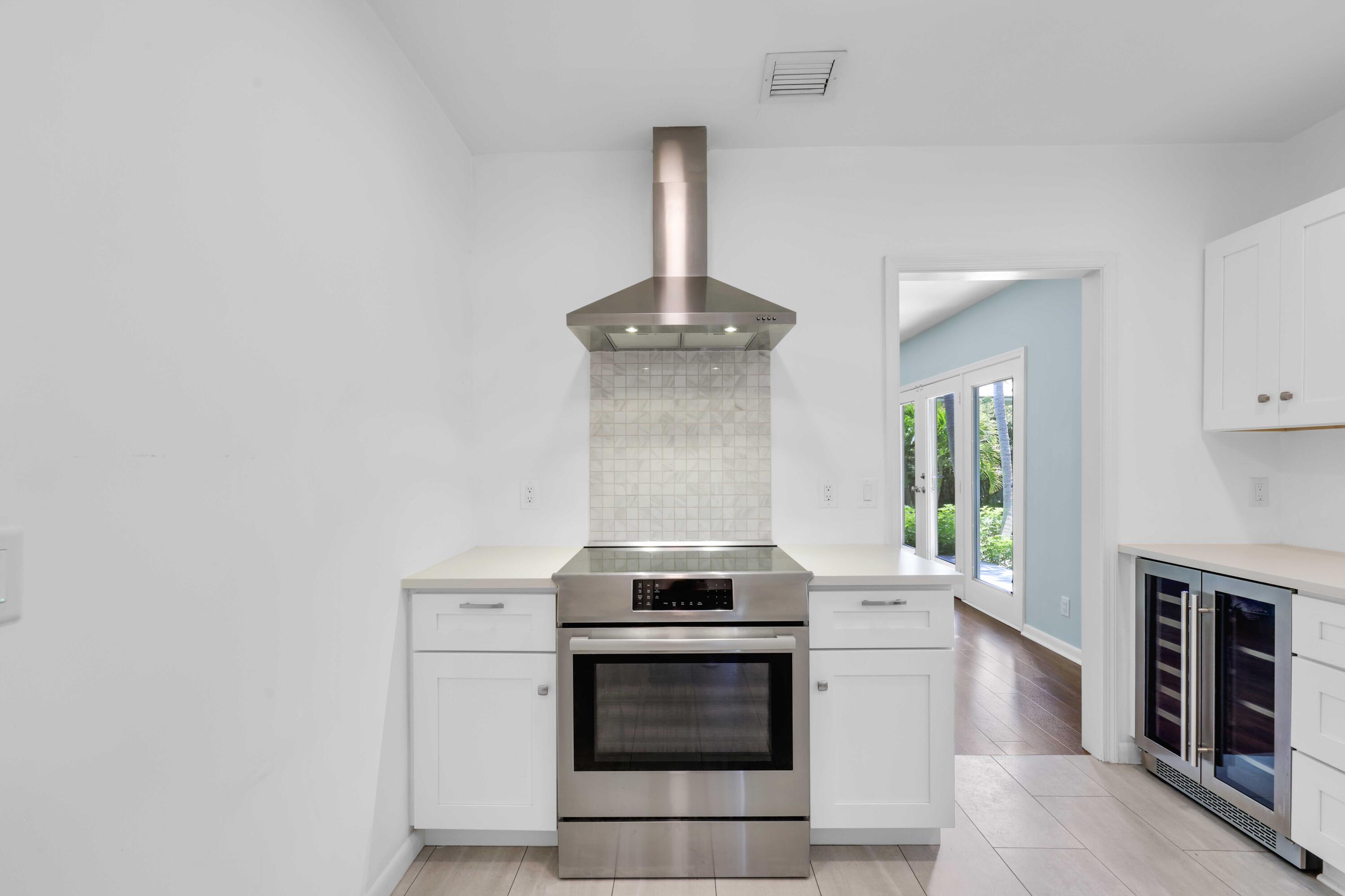 246 Merrain Road Palm Beach, FL 33480 - Photo 15 of 31 a kitchen with granite countertop a stove and white cabinets