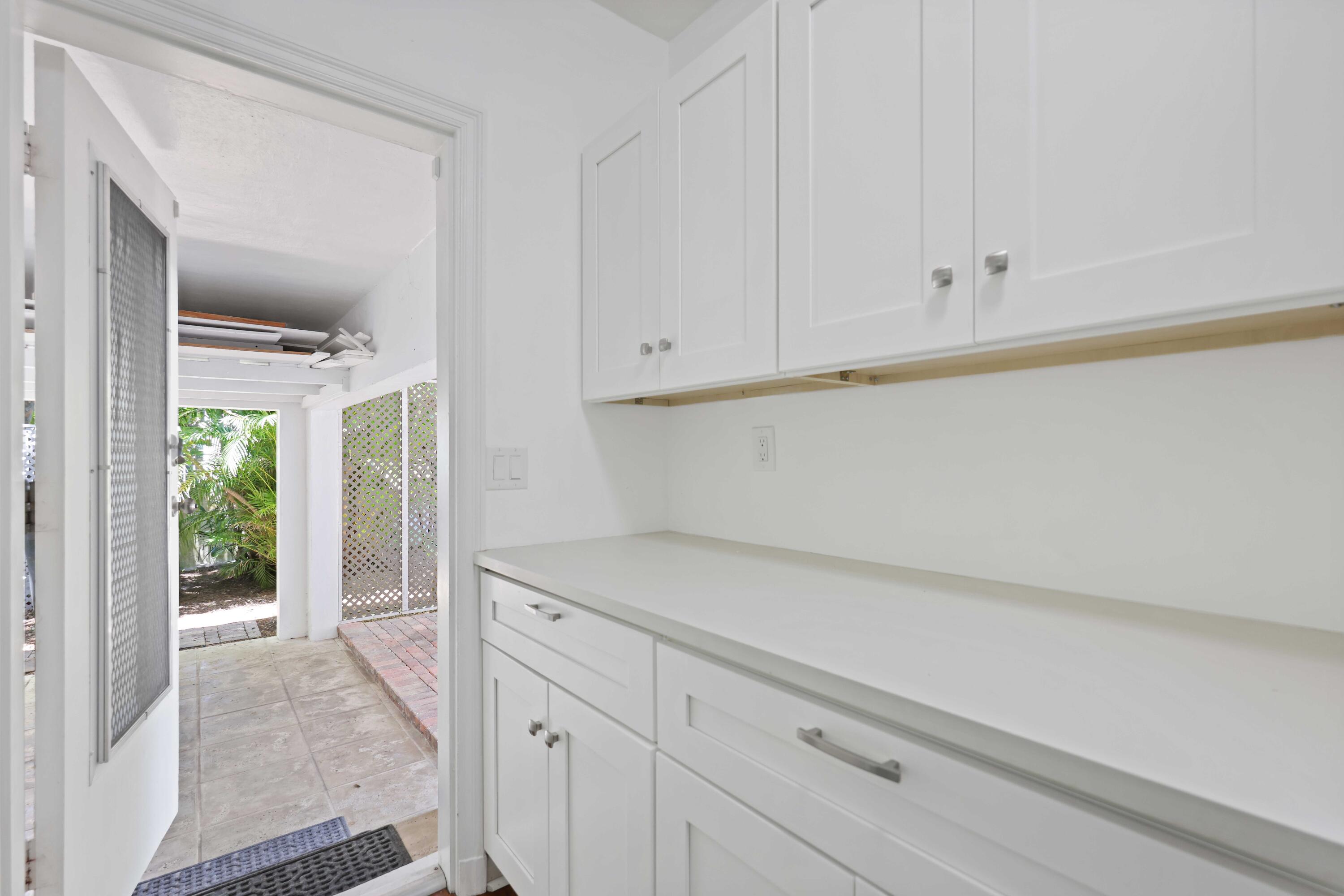 246 Merrain Road Palm Beach, FL 33480 - Photo 17 of 31 a kitchen with white cabinets and a window
