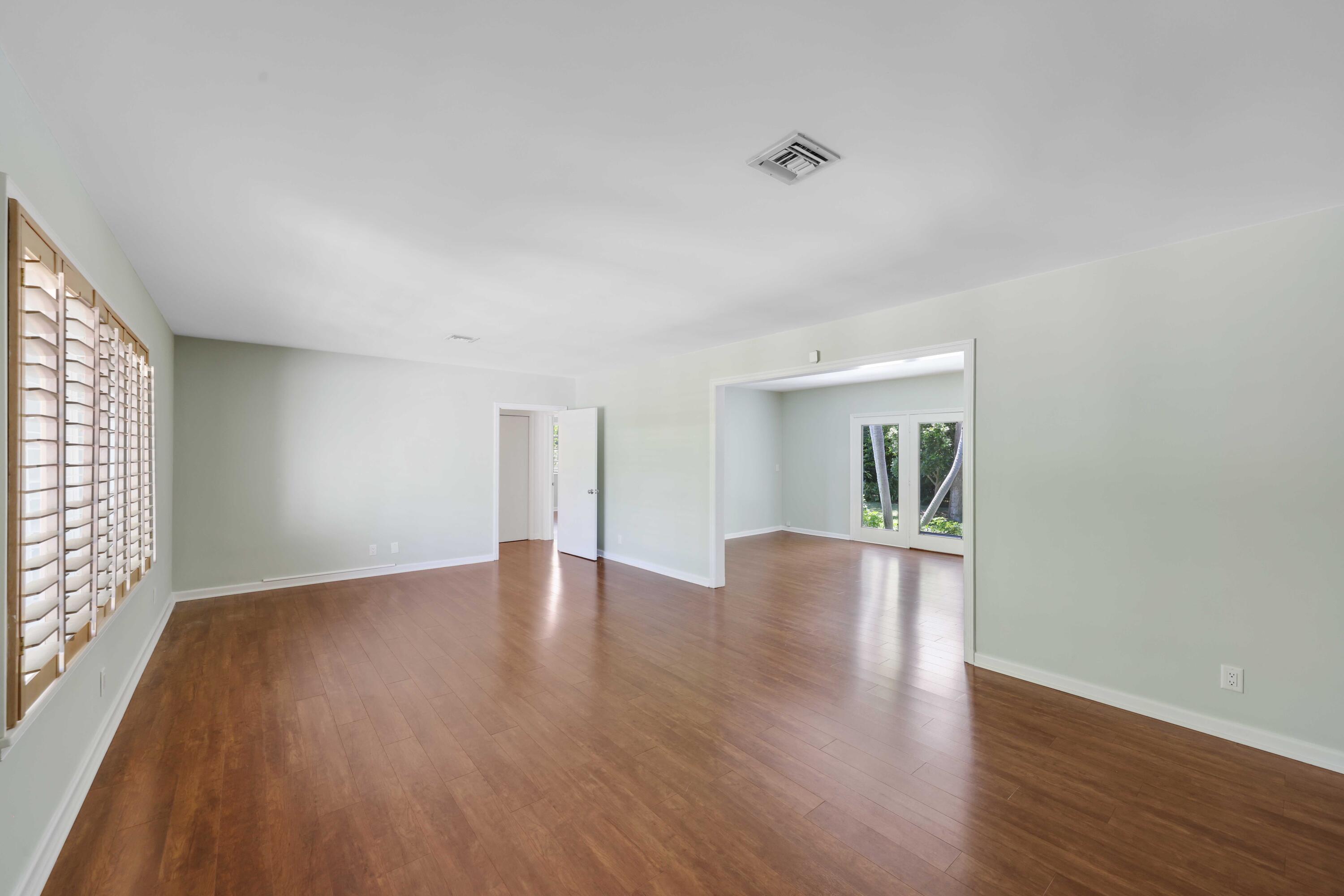 246 Merrain Road Palm Beach, FL 33480 - Photo 3 of 31 a view of an empty room with wooden floor and a window