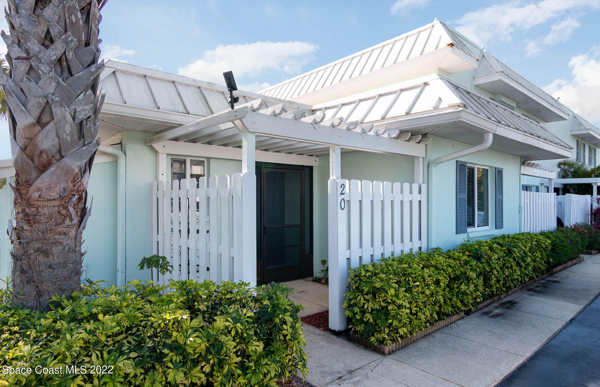 2 Country Club Road, Unit 20 Cocoa Beach, FL 32931 - Photo 1 of 23 a view of a house with a small yard and plants