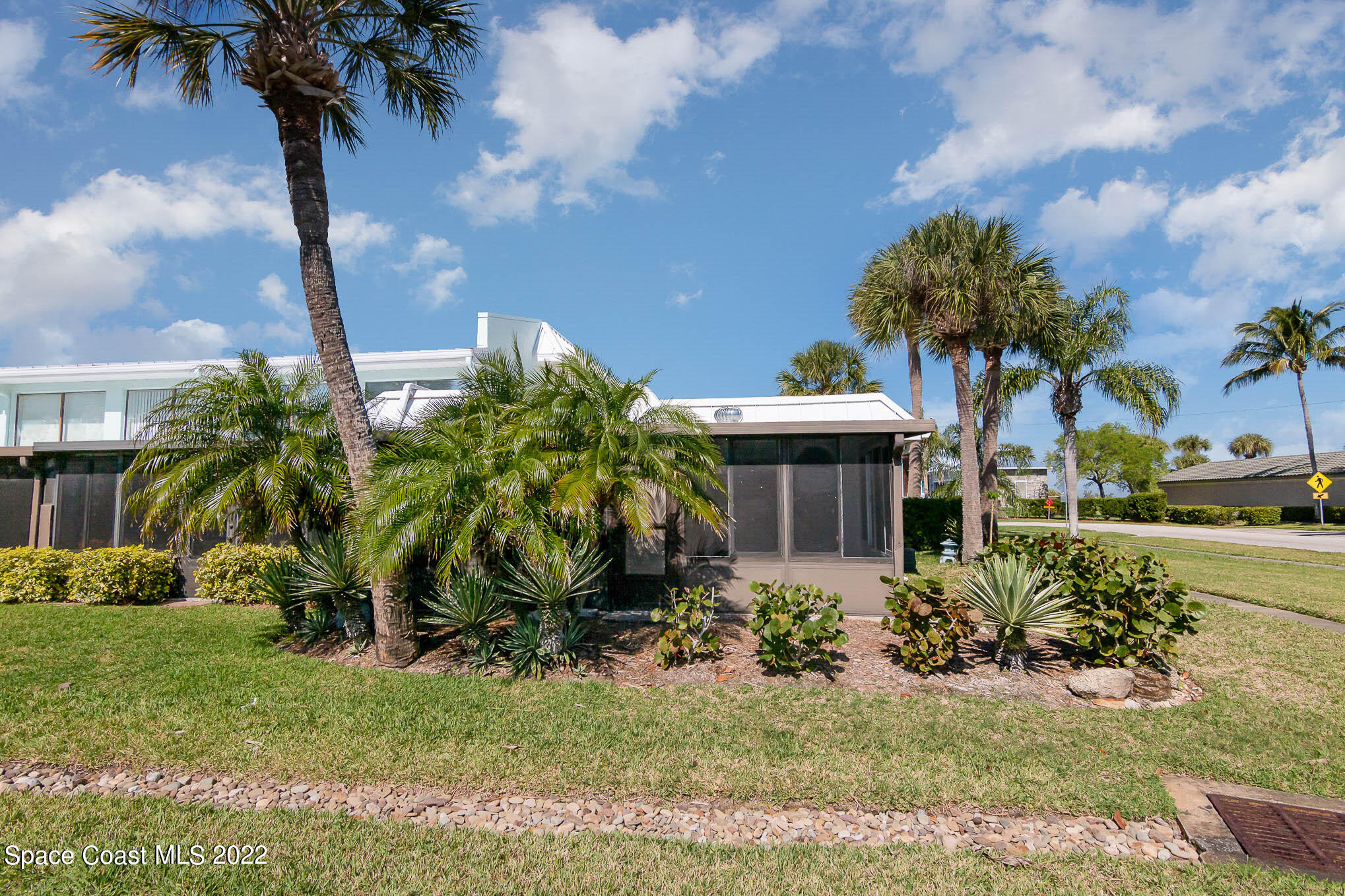 2 Country Club Road, Unit 20 Cocoa Beach, FL 32931 - Photo 22 of 23 a front view of a house with garden