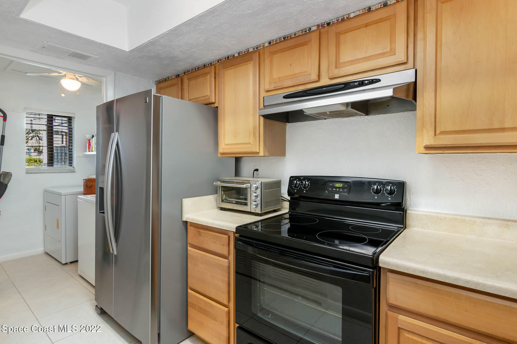 2 Country Club Road, Unit 20 Cocoa Beach, FL 32931 - Photo 7 of 23 a kitchen with a refrigerator and a stove top oven