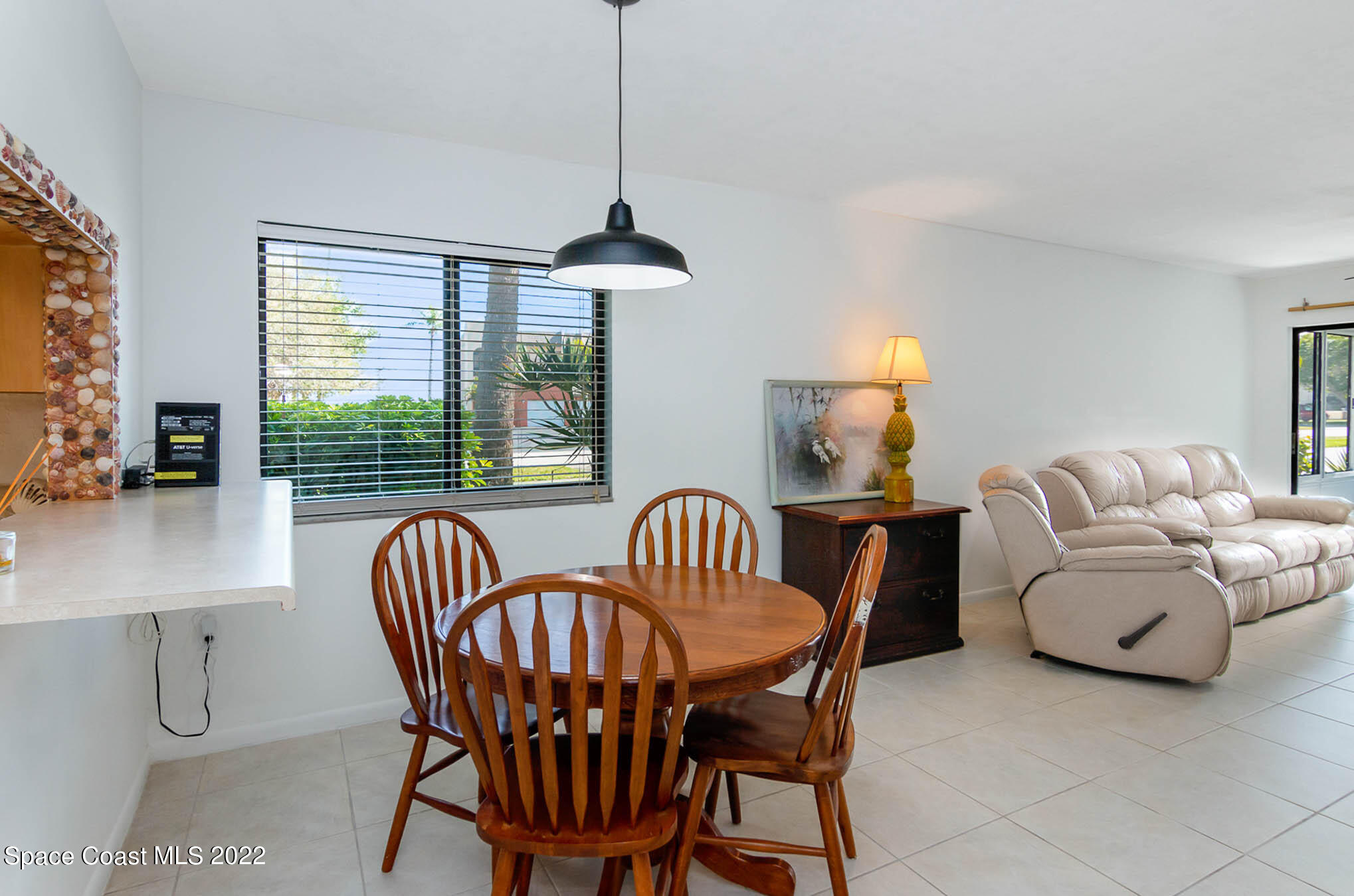 2 Country Club Road, Unit 20 Cocoa Beach, FL 32931 - Photo 10 of 23 a dining room with furniture a chandelier and window