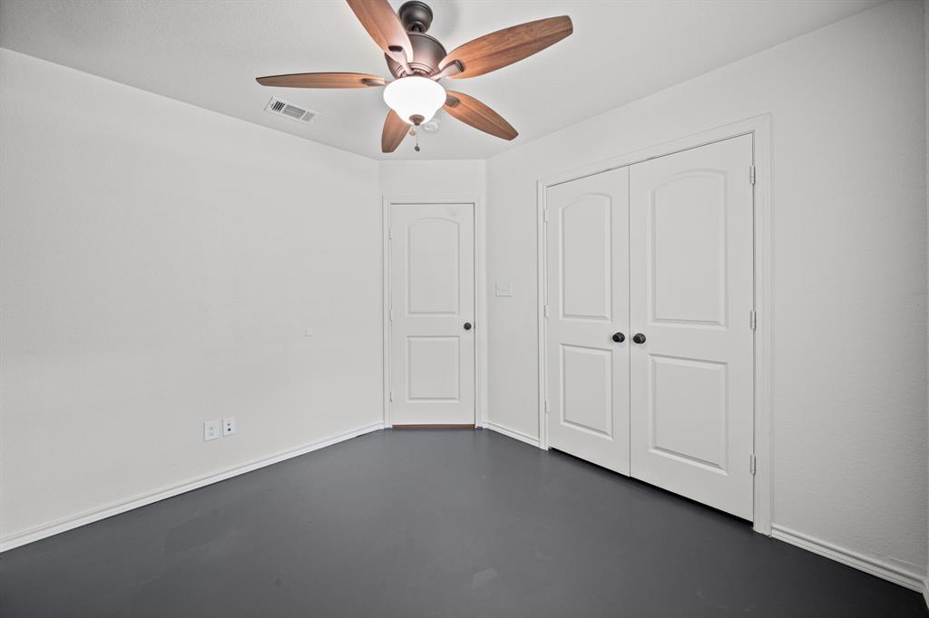 229 Firefly Drive Springtown, TX 76082 - Photo 17 of 33 Room featuring dark flooring, light walls, and a ceiling fan with wood-finish blades